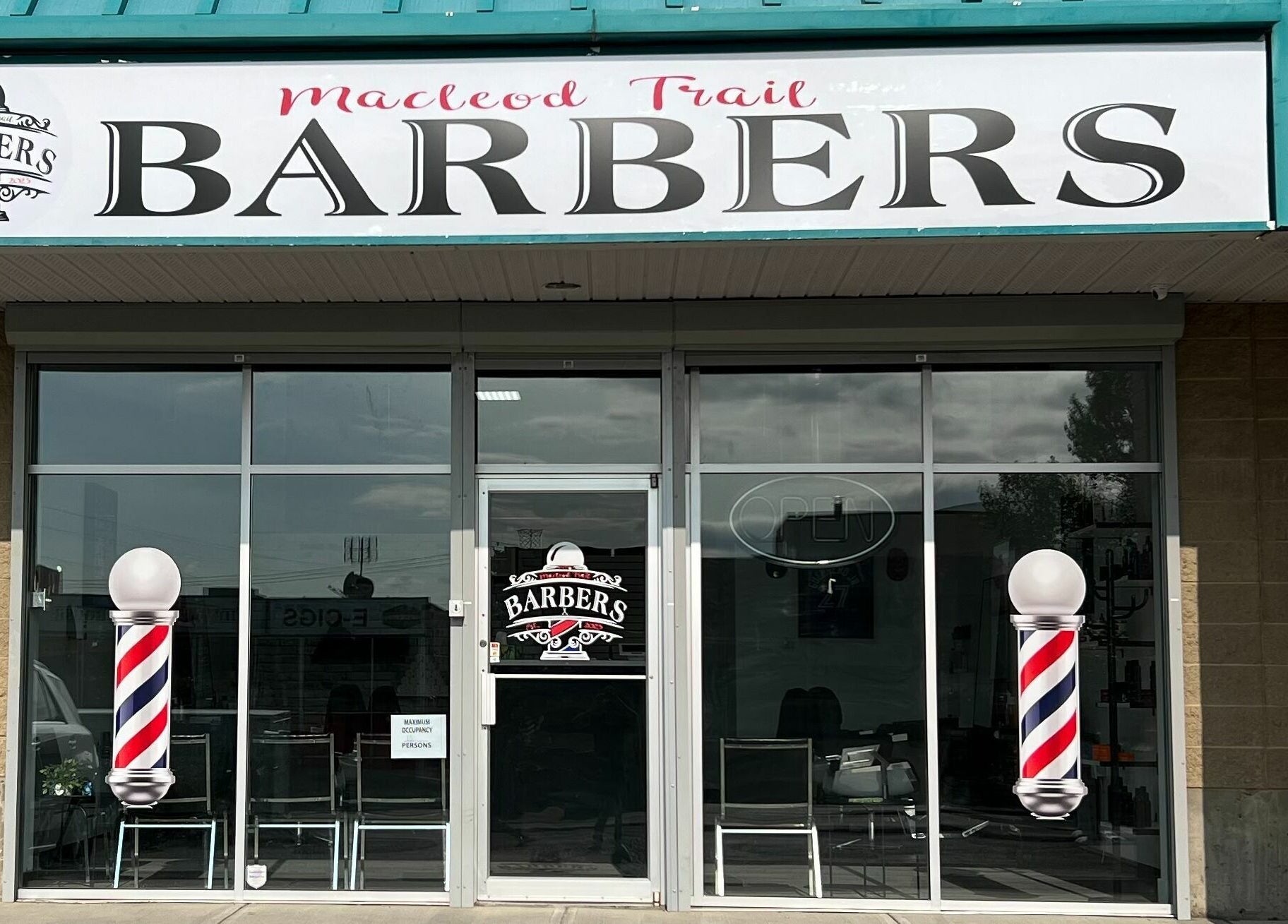 Macleod Trail Barbers storefront in Calgary, Alberta, CA with a classic barber pole decoration.