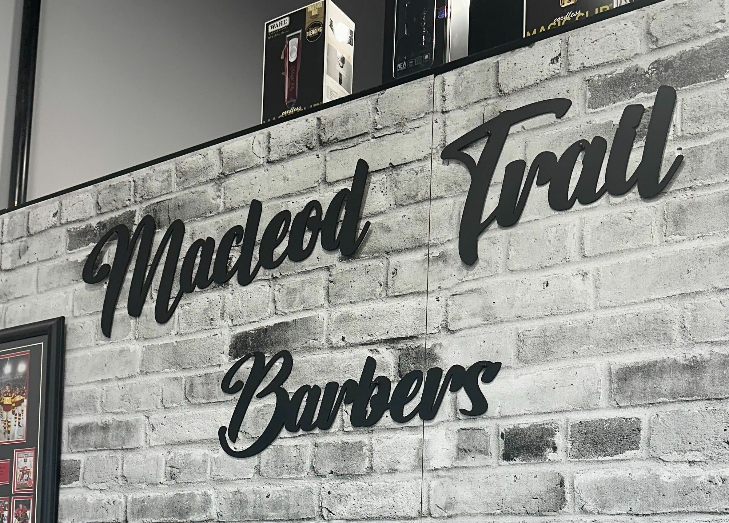 Macleod Trail Barbers sign on rustic brick wall in Calgary, Alberta, CA.