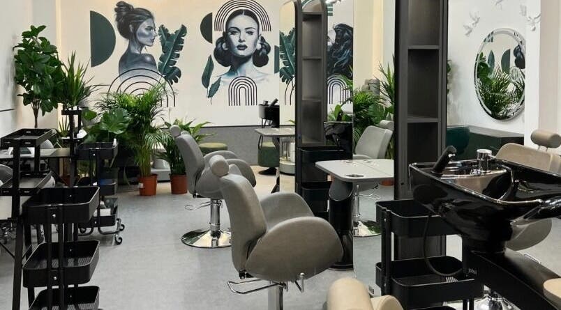 Interior of Fam Beauty London salon in London, England, GB, featuring stylish chairs and vibrant plants.