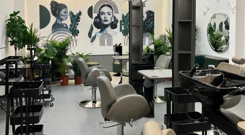 Interior of Fam Beauty London salon in London, England, GB, featuring stylish chairs and vibrant plants.
