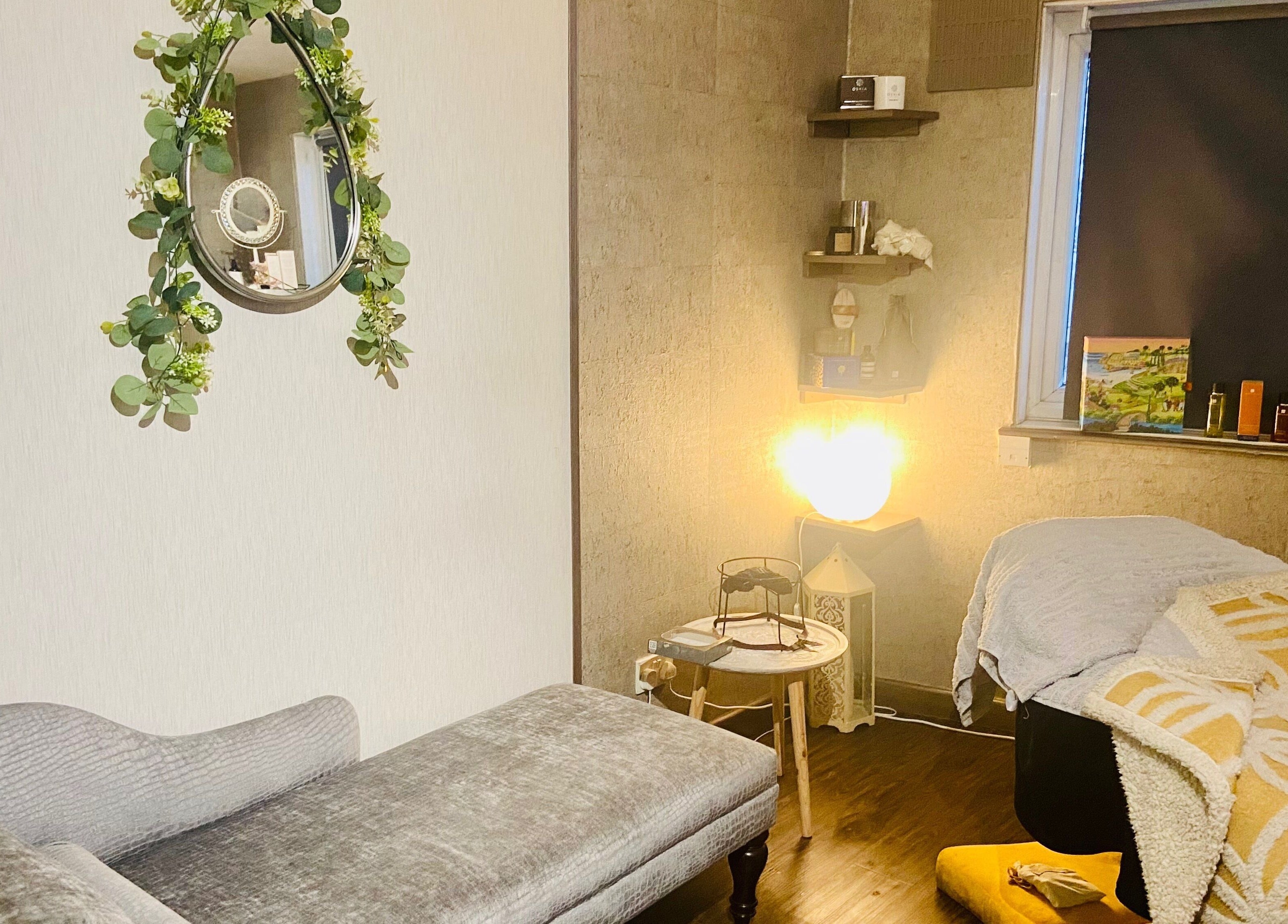 Cozy treatment room at Celestial Glow, Brockenhurst, England, GB with elegant decor and soft lighting.