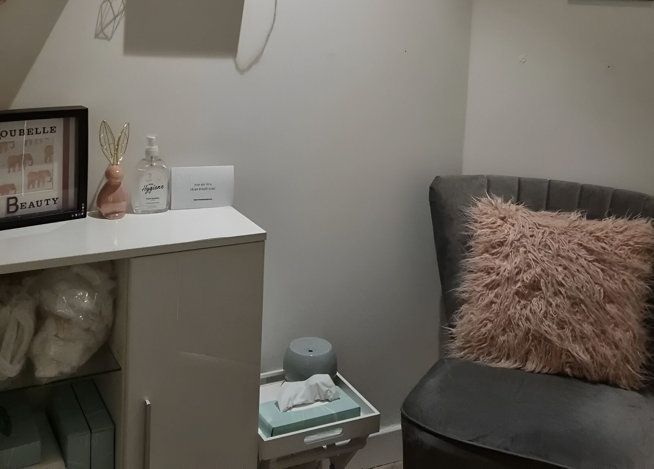 A cozy corner at Loubelle Beauty in Aberdeen, Scotland, GB featuring a plush chair and decorative items.