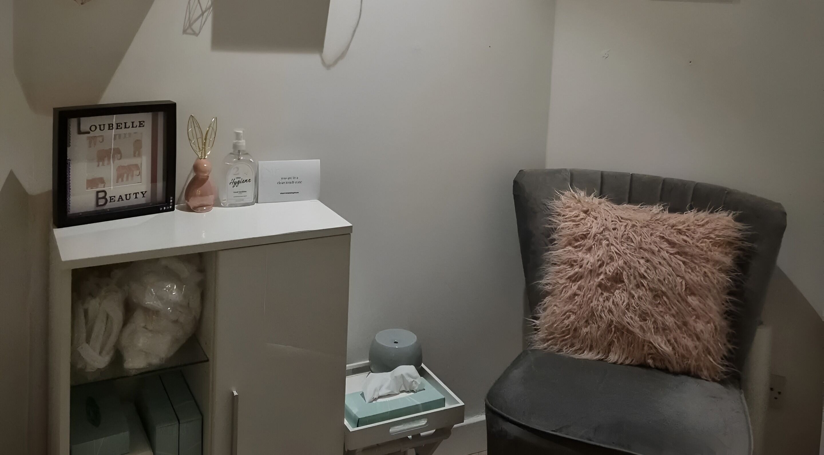 A cozy corner at Loubelle Beauty in Aberdeen, Scotland, GB featuring a plush chair and decorative items.
