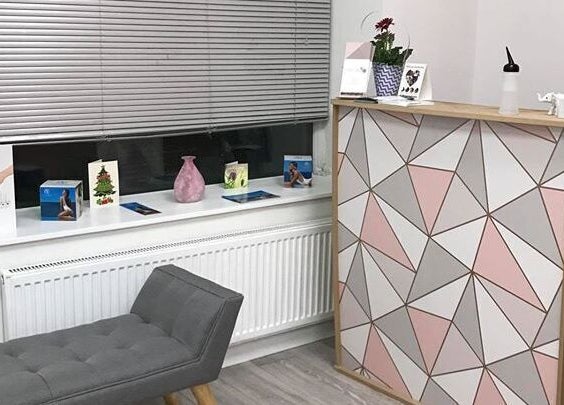 Chic reception area at Loubelle Beauty in Aberdeen, Scotland with geometric desk and cozy decor.