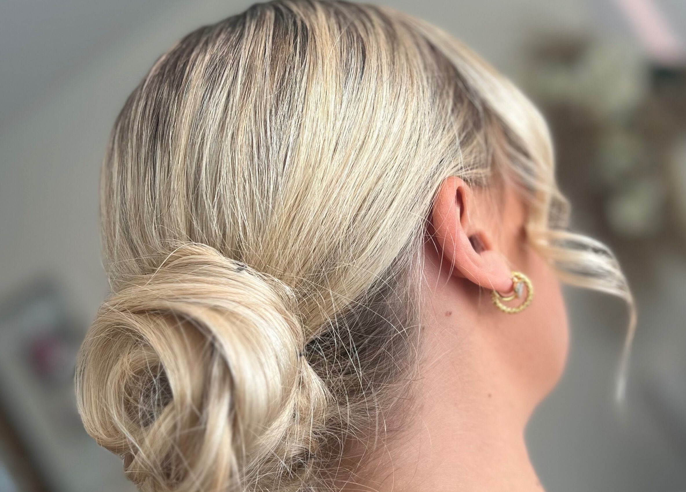 Blonde hair styled in an elegant updo at Signature Blonde, Leeds, England, GB.