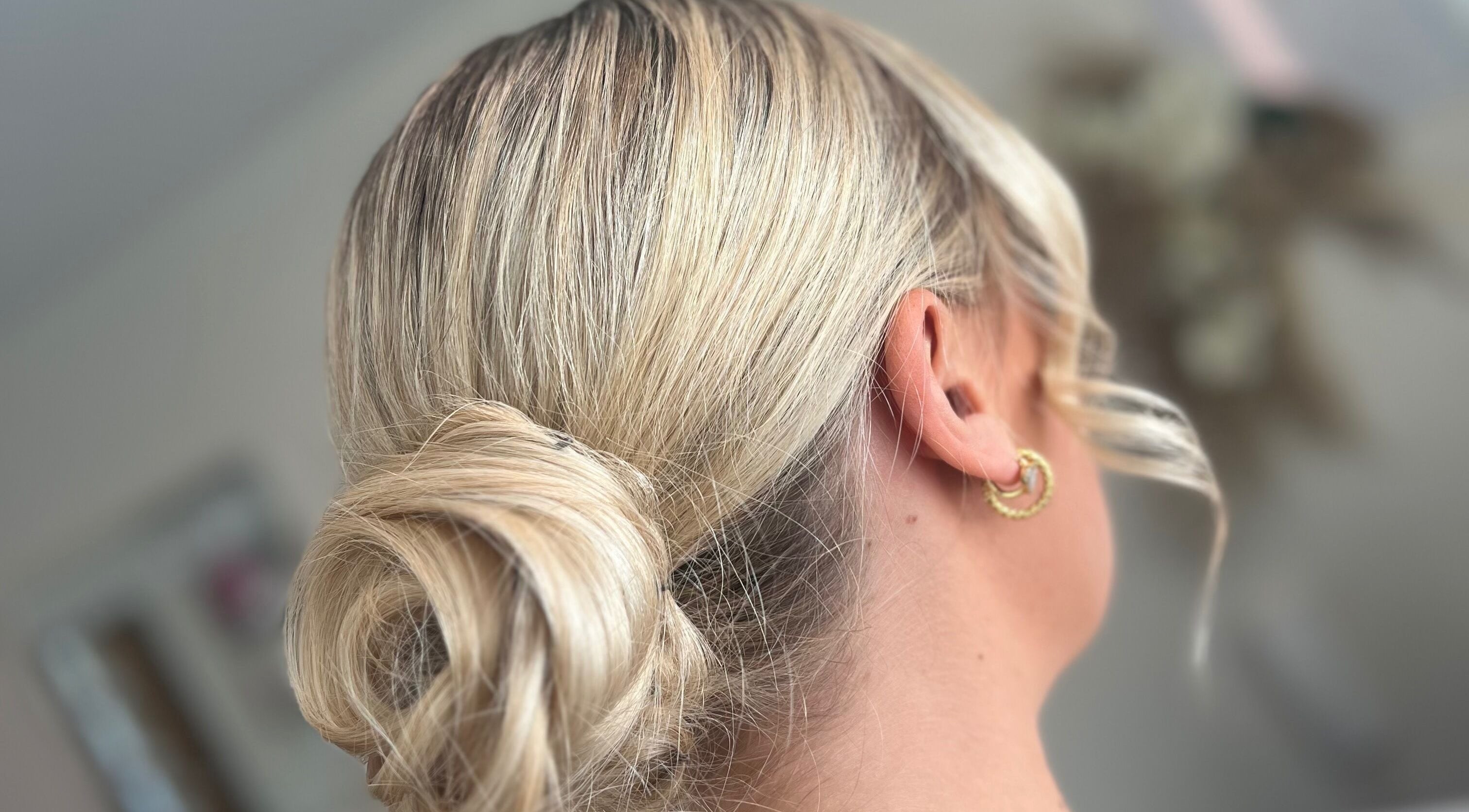 Blonde hair styled in an elegant updo at Signature Blonde, Leeds, England, GB.