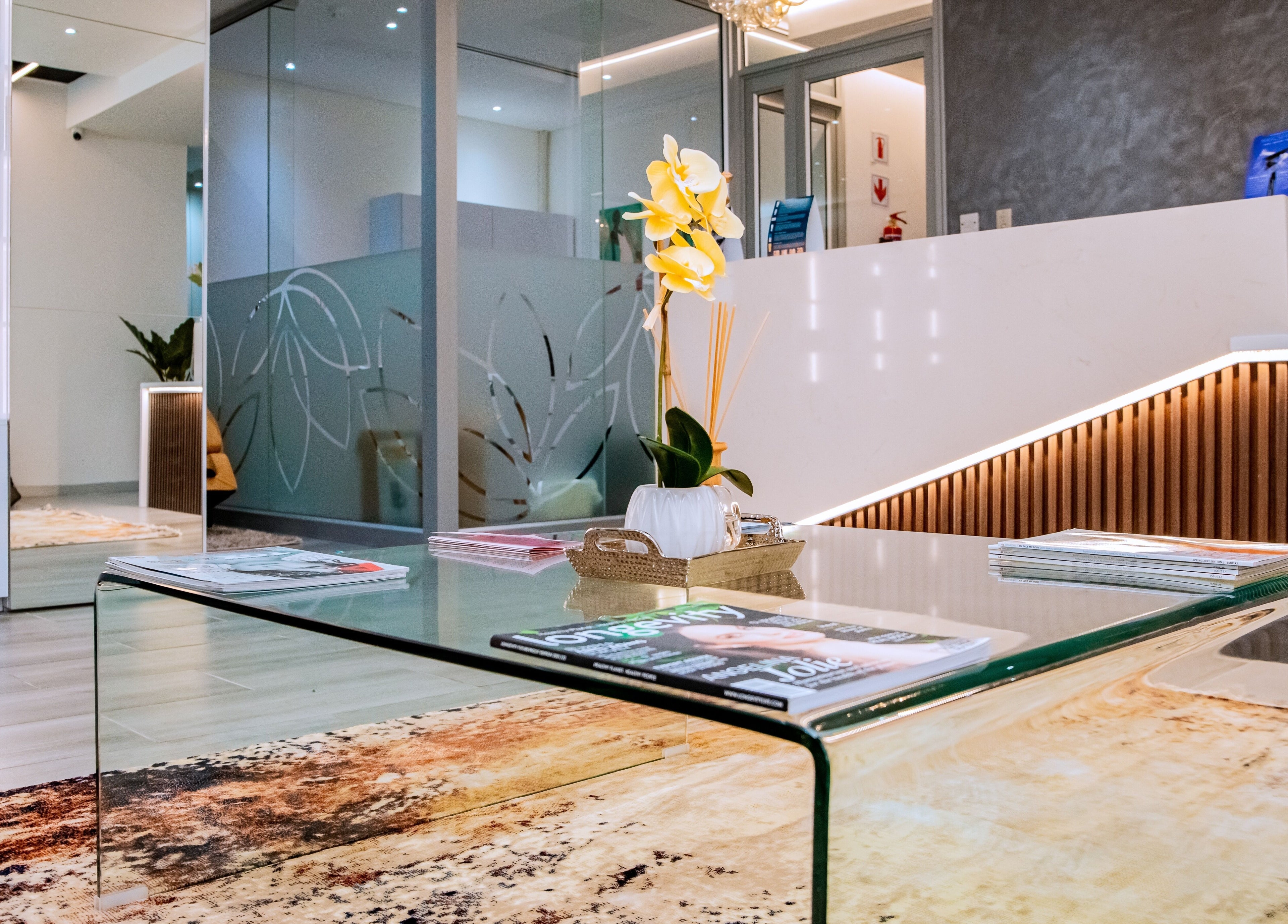 Elegant glass table at Anue Medical Spa, Gaborone City, BW reception area with decor.
