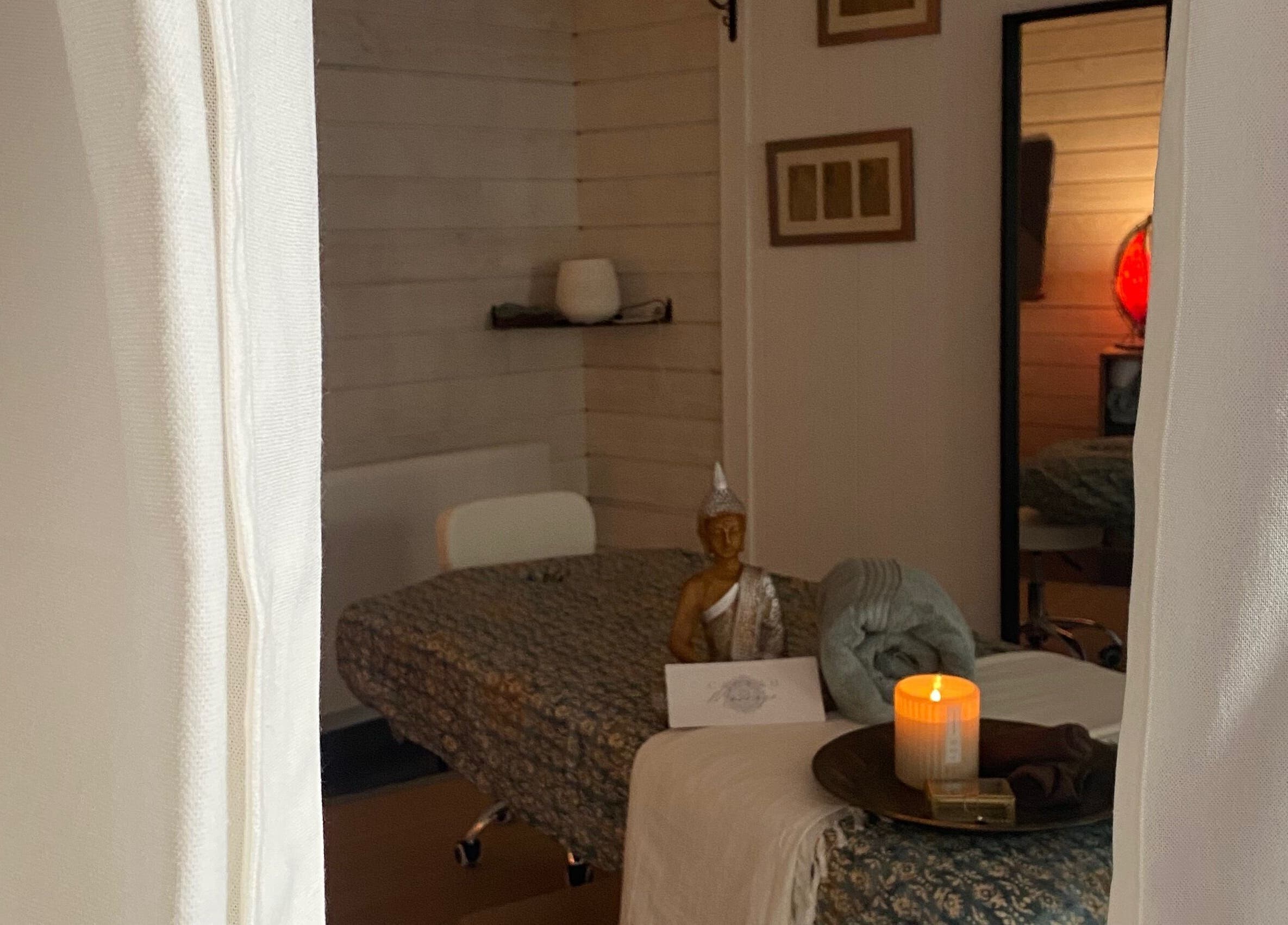 Salle apaisante de PRĀNA Massage à Les Rousses, Bourgogne-Franche-Comté, FR, avec bougie allumée.