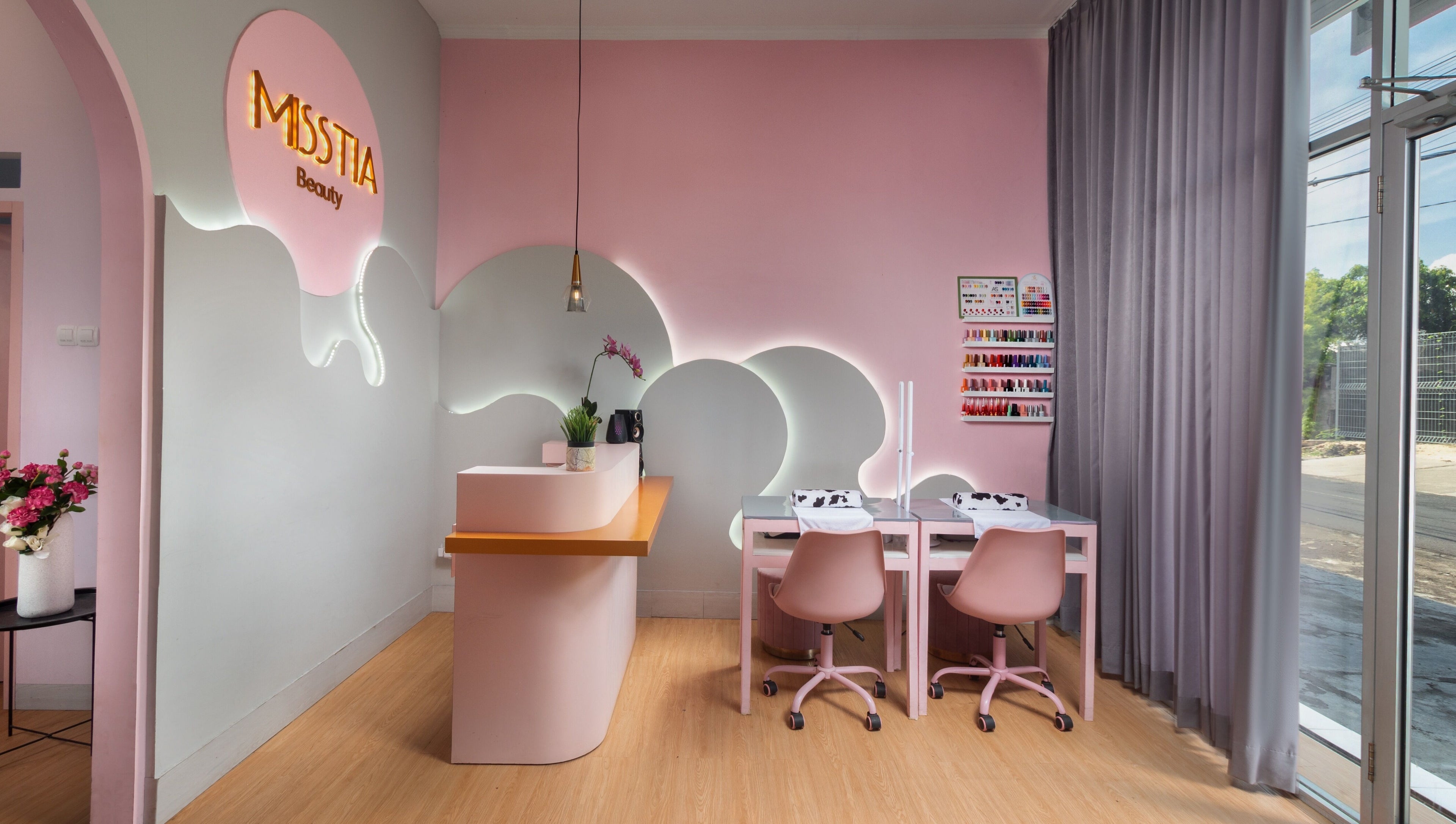Interior of Misstia Beauty, Bali. Pink decor with manicure stations and floral accents.