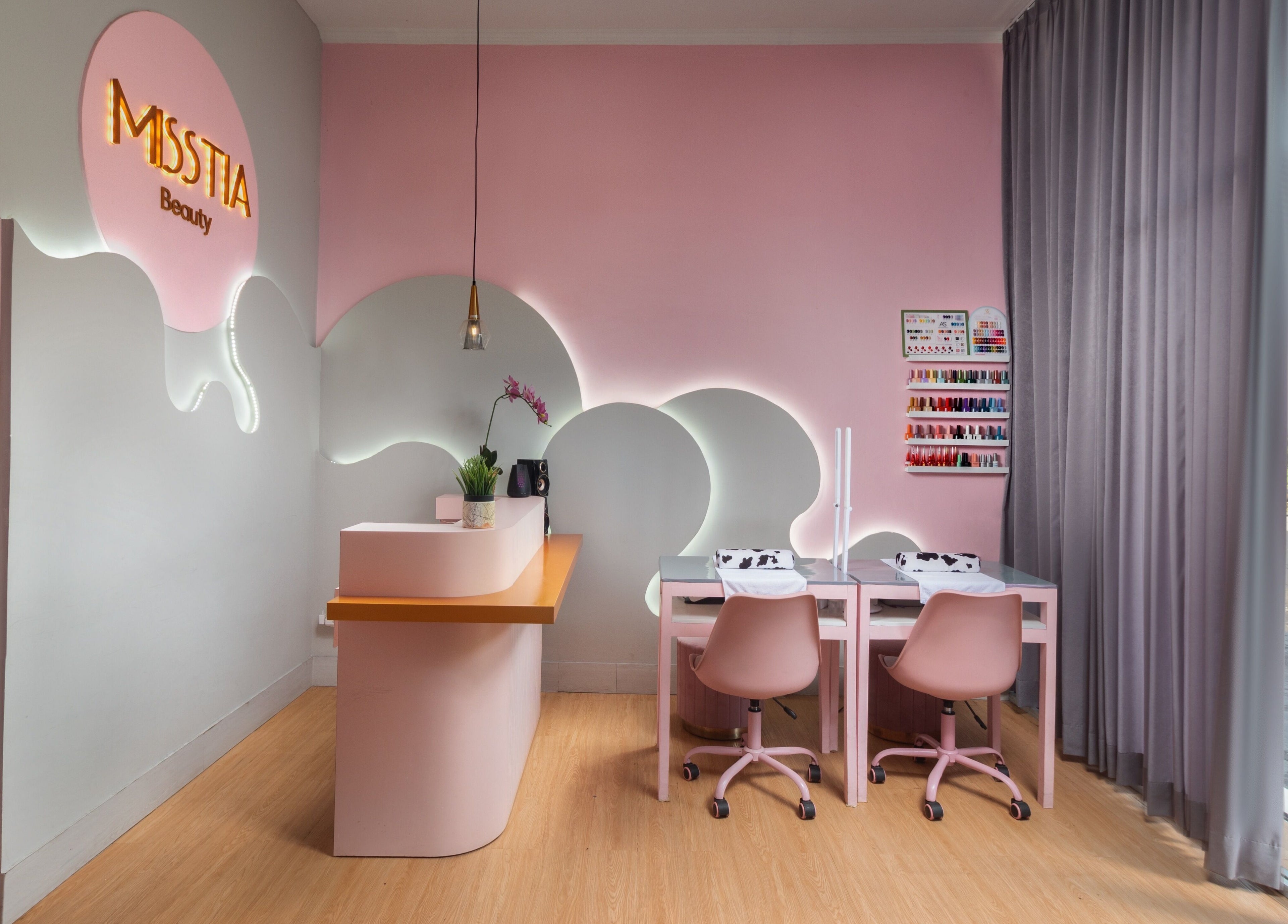 Interior of Misstia Beauty, Bali. Pink decor with manicure stations and floral accents.