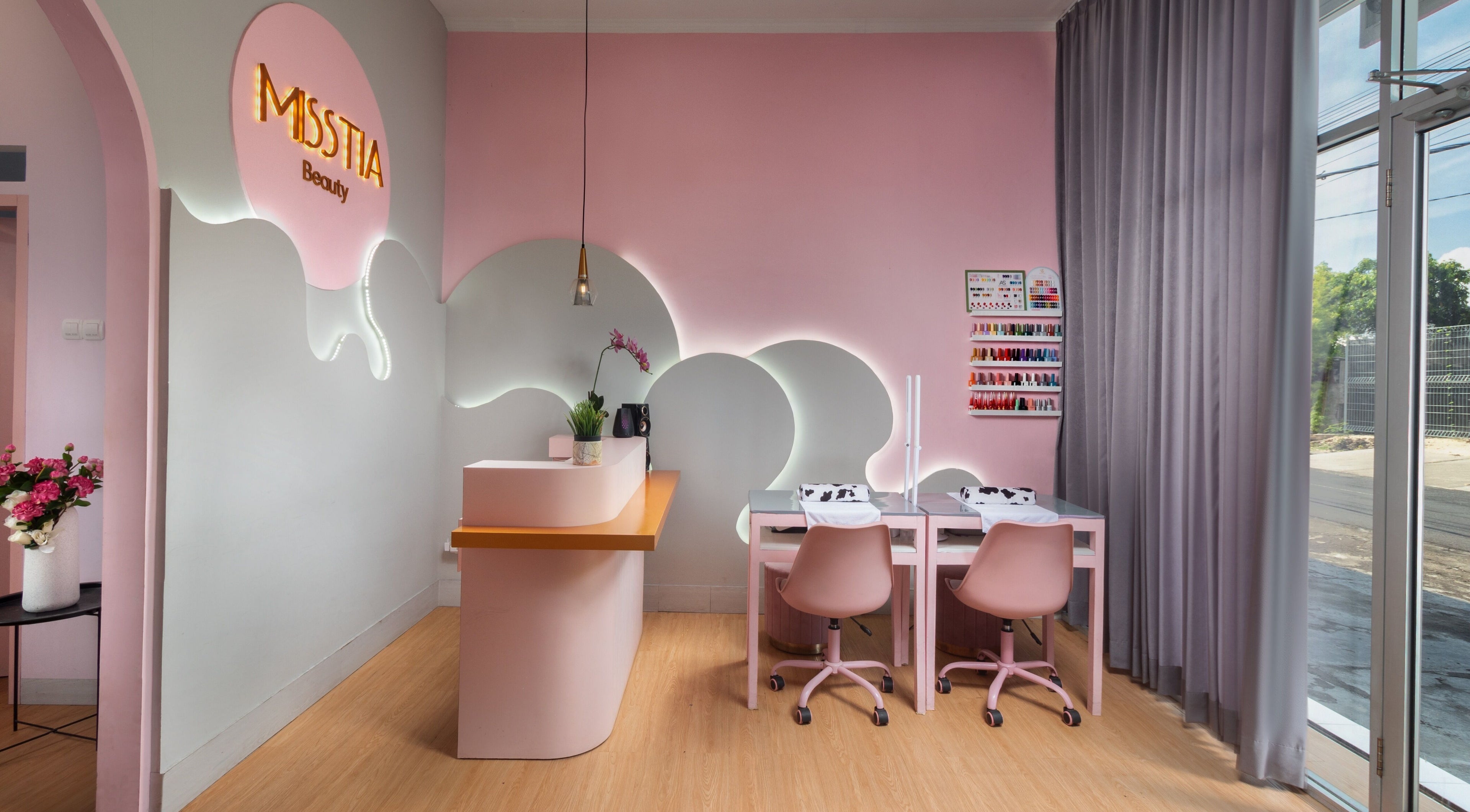 Interior of Misstia Beauty, Bali. Pink decor with manicure stations and floral accents.