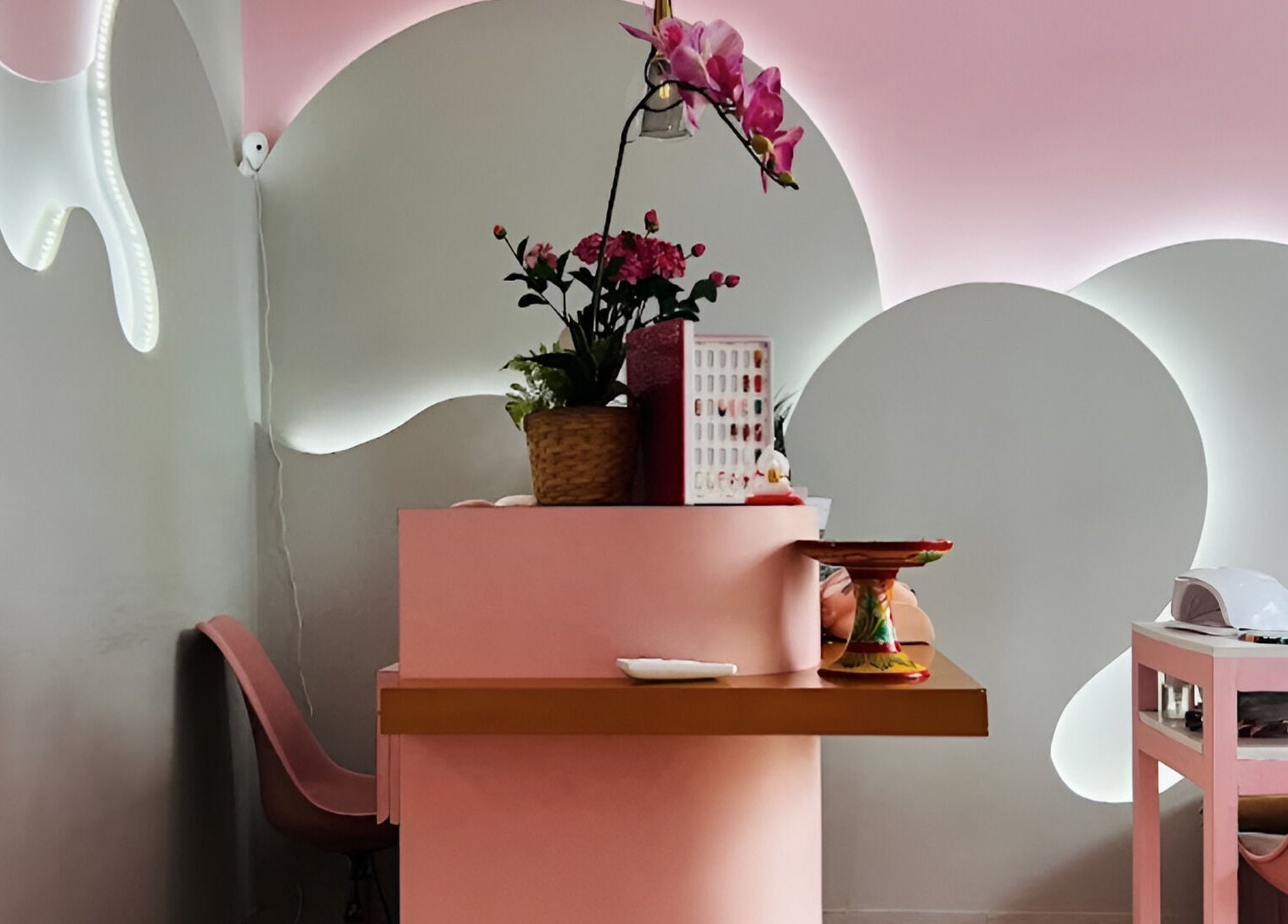 Elegant pink reception desk at Misstia Beauty, Bali, Bali, ID with floral decor and nail polish display.