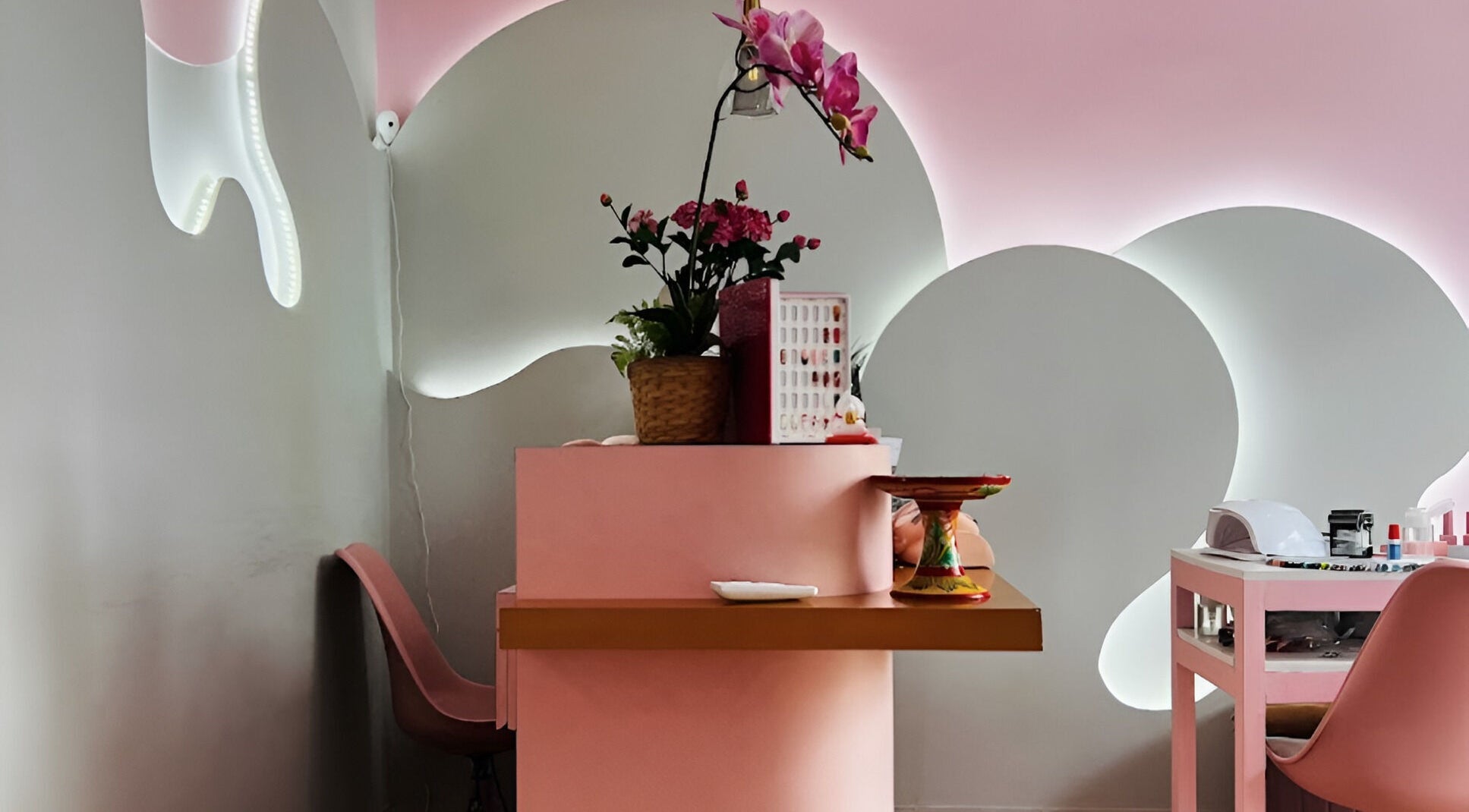 Elegant pink reception desk at Misstia Beauty, Bali, Bali, ID with floral decor and nail polish display.