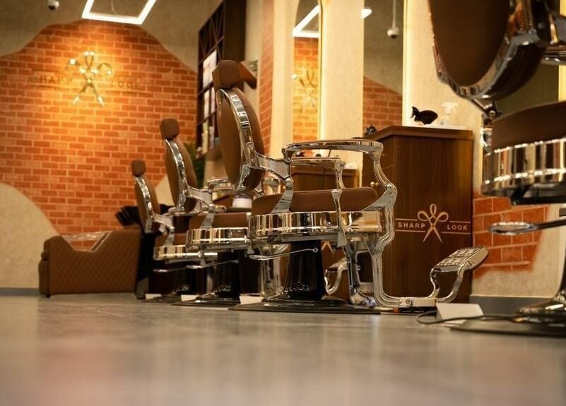 Sleek barber chairs at شارب لوك حطين - Sharp Look Hittin, Riyadh, Riyadh Province, SA, in a stylish setting.