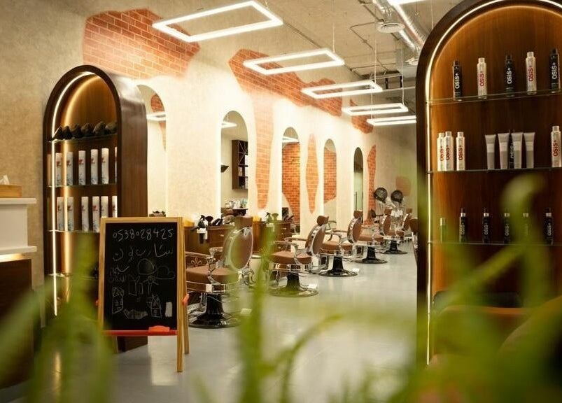 Modern salon interior at Sharp Look Hittin, Riyadh, showcasing stylish chairs and product shelves.