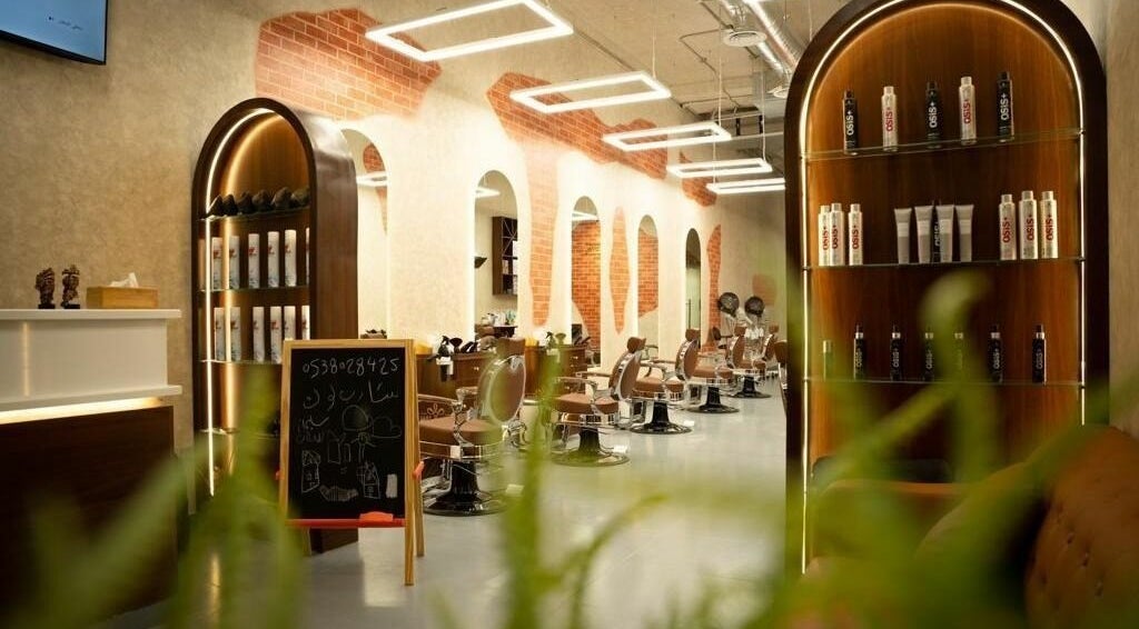 Modern salon interior at Sharp Look Hittin, Riyadh, showcasing stylish chairs and product shelves.