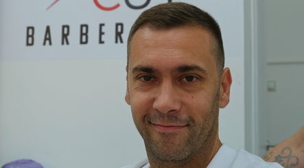 Frizer u Cut Cut Barbershop i Frizerskom Salonu, Суботица, Војводина, RS, blizu znaka salona.