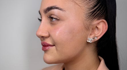 Close-up of a woman's radiant skin and earrings at Paradox Aesthetics, Worcester, England, GB.