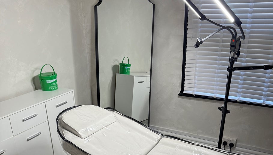 Calm treatment room at Paradox Aesthetics, Worcester, England, GB with a well-lit bed and large mirror.