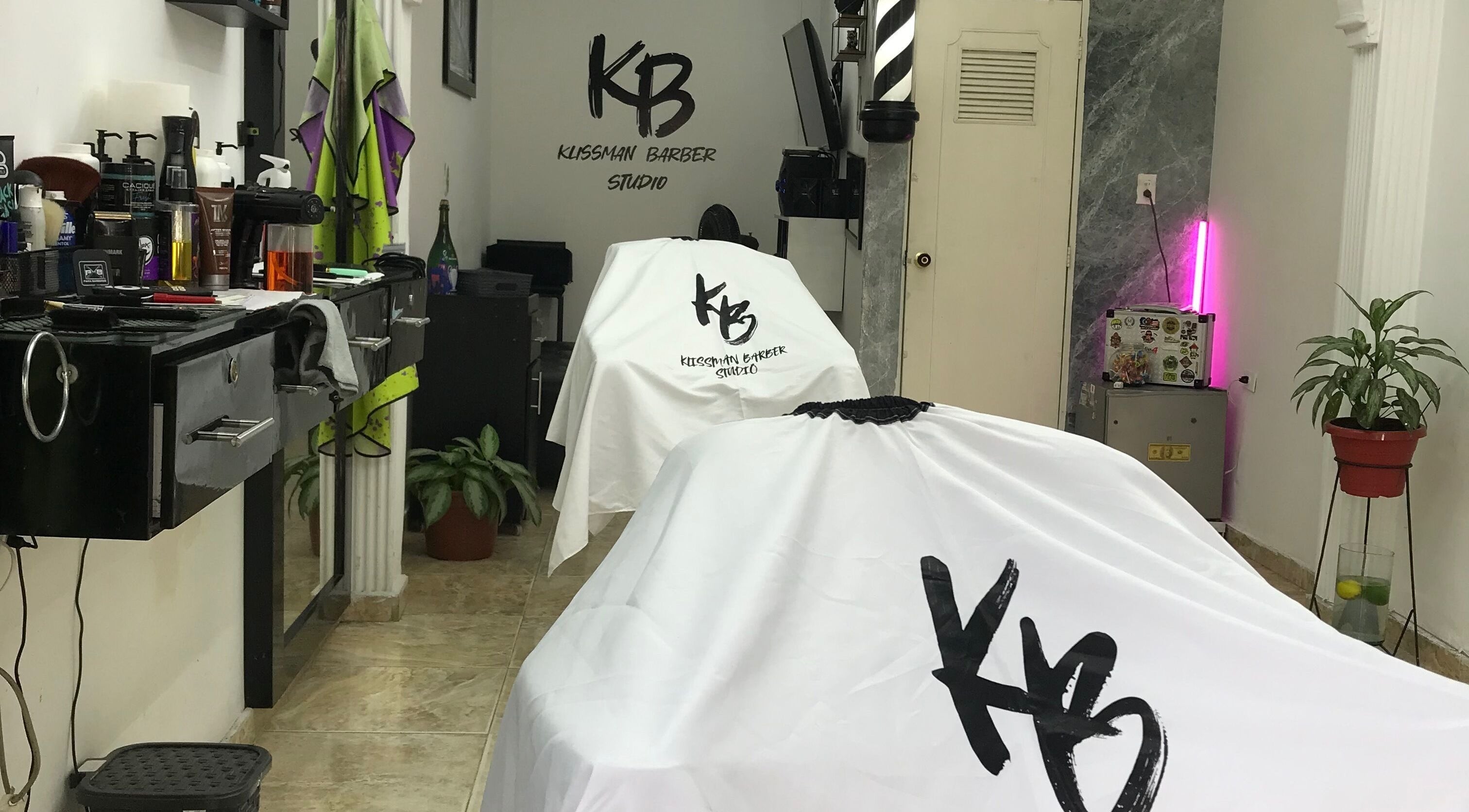 Interior moderno de Klissman Barber Studio en Cali, Valle Del Cauca, CO con cubiertas blancas y decoración elegante.