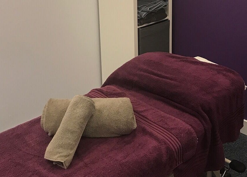 Relaxing massage room at Molly Sports Massage at Locker 27, Addlestone, England, GB, featuring plush purple linens.