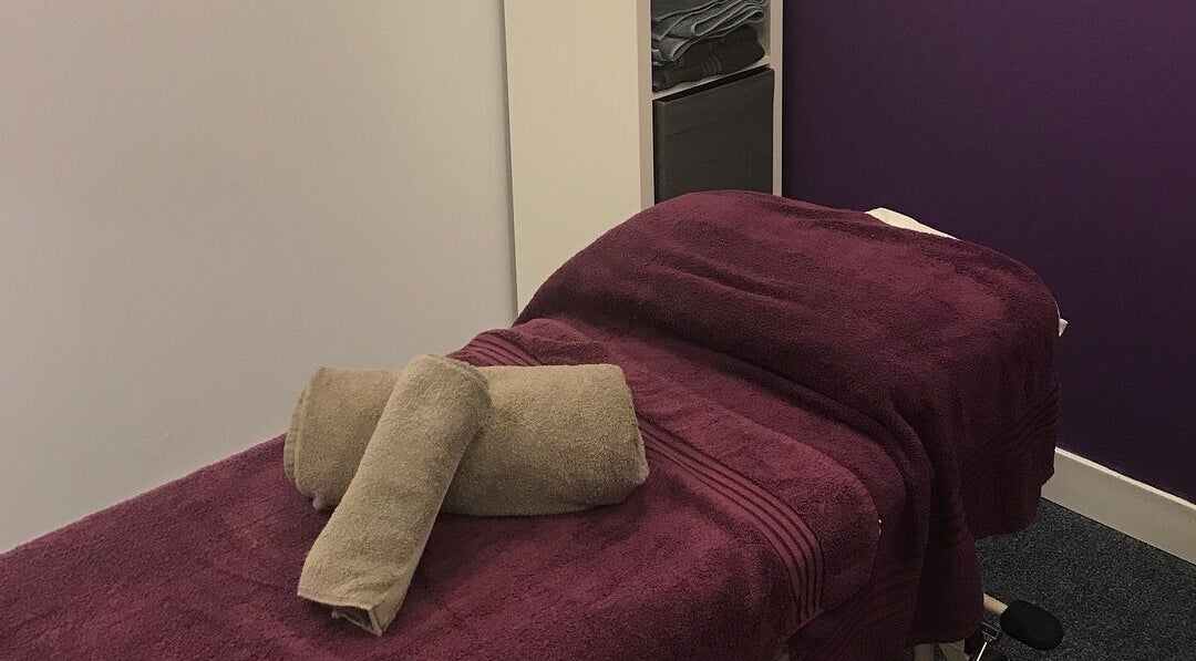 Relaxing massage room at Molly Sports Massage at Locker 27, Addlestone, England, GB, featuring plush purple linens.