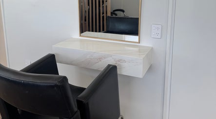 Elegant styling station at Amelia Maeve Hair, Blenheim, Marlborough Region, NZ with a modern chair and mirror.