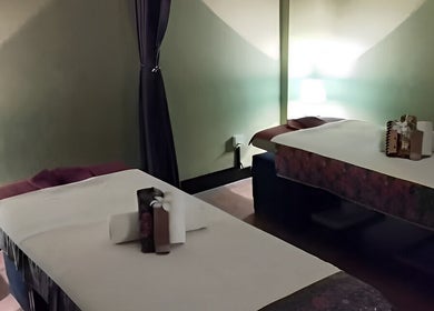 Relaxing massage room at Touch of Wellness Spa in Kota Kinabalu, Sabah, MY, featuring two comfortable beds.