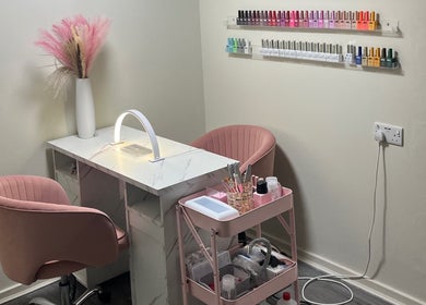 Stylish nail station at Marble Beauty Bar, Glasgow, Scotland, GB, with pink chairs and nail polish display.