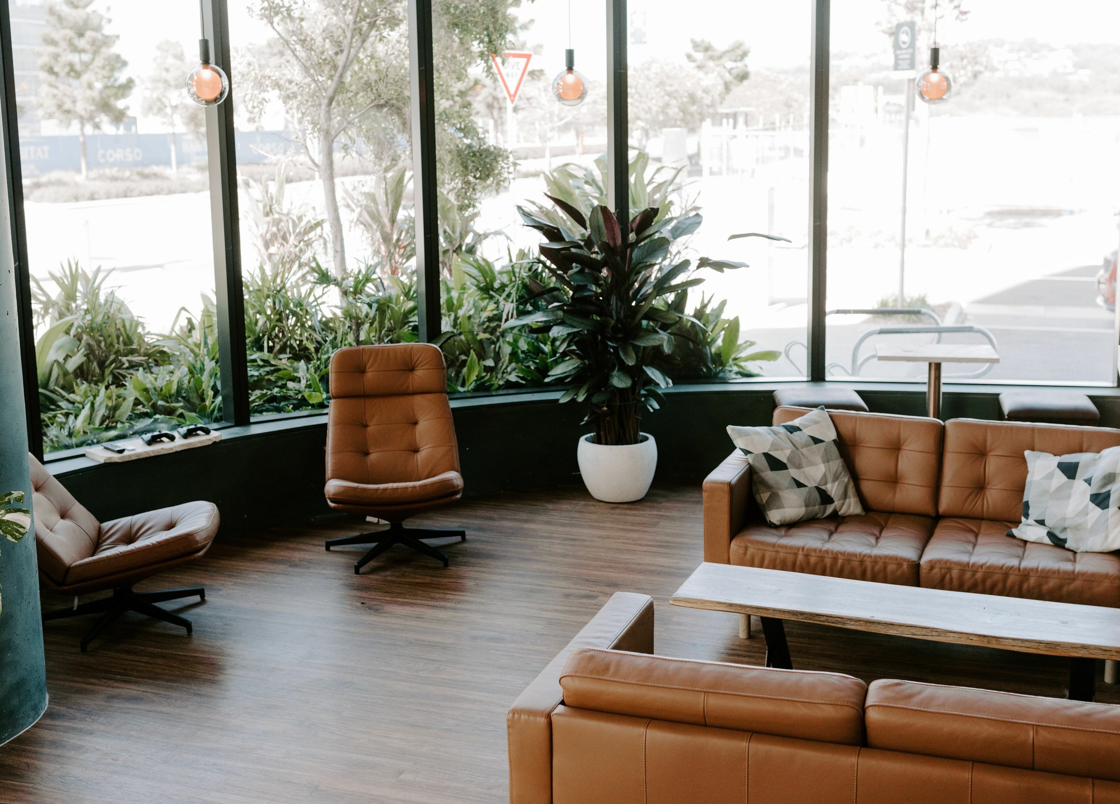 Calm and stylish seating area at Stallion in Maroochydore, QLD, AU with leather chairs and lush greenery.