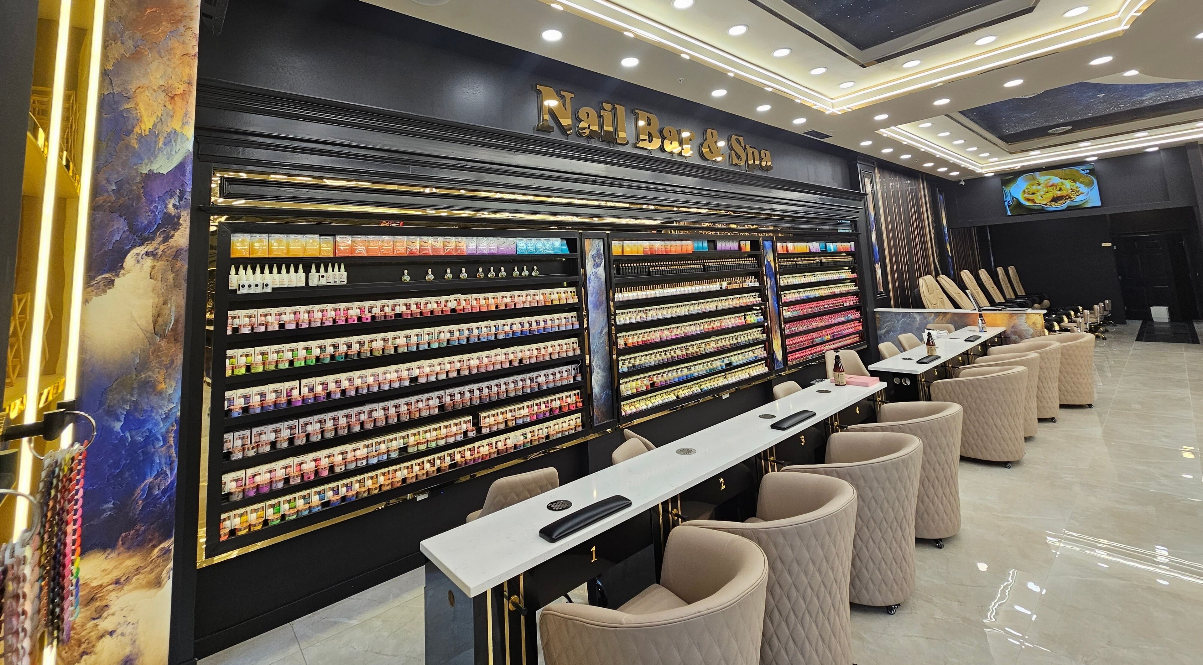 Interior of MV Nail Bar and Spa in Jeffersonville, Indiana, US showcasing nail stations and color displays.