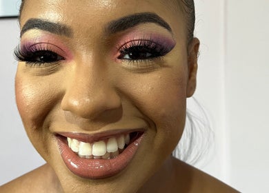 A smiling client with vibrant makeup at Beauty Lounge TT, Port of Spain, Port of Spain Corporation, TT.