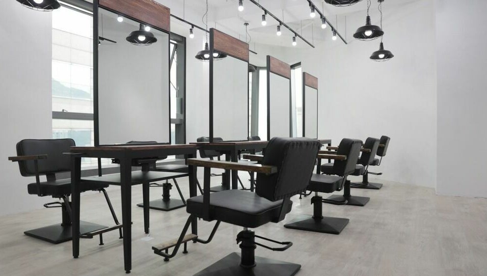 Modern salon setup at ASSORT HONG KONG, Hong Kong Island, HK, featuring sleek black chairs and mirrors.