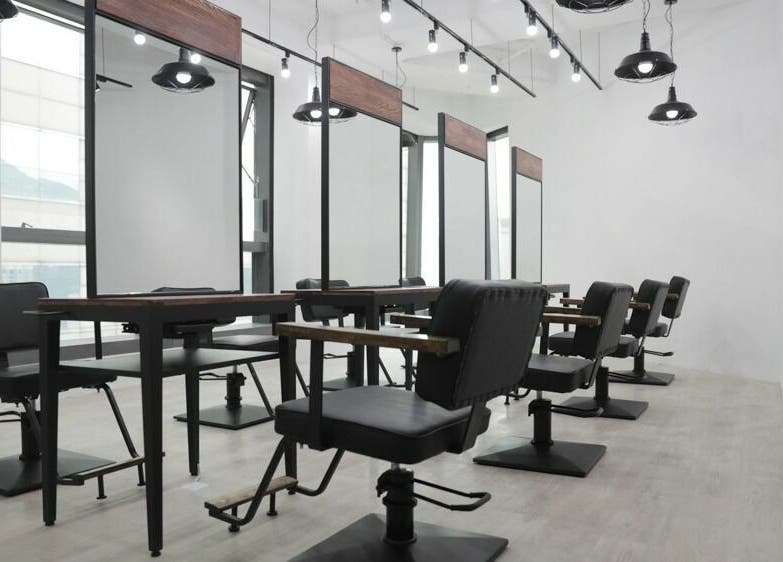 Modern salon setup at ASSORT HONG KONG, Hong Kong Island, HK, featuring sleek black chairs and mirrors.