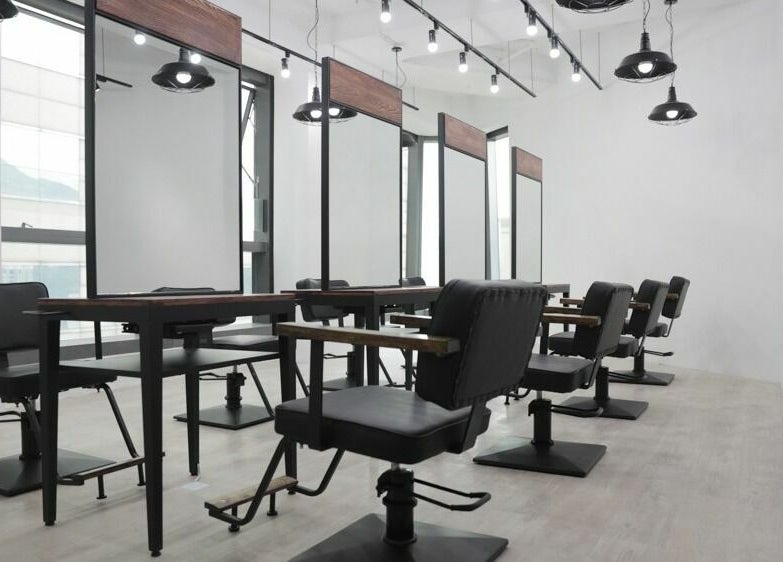 Modern salon setup at ASSORT HONG KONG, Hong Kong Island, HK, featuring sleek black chairs and mirrors.