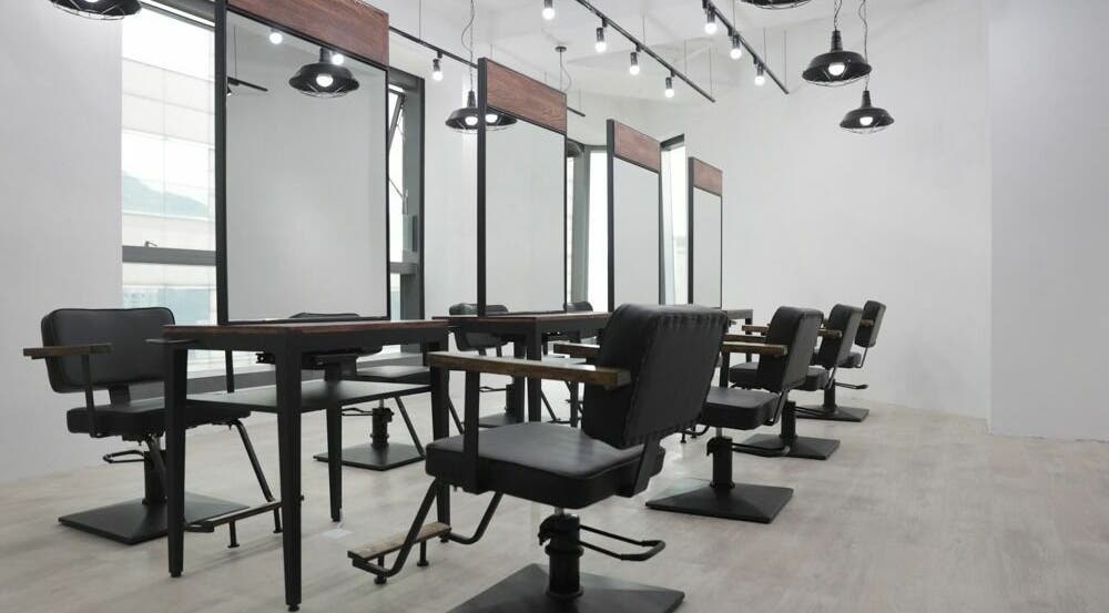 Modern salon setup at ASSORT HONG KONG, Hong Kong Island, HK, featuring sleek black chairs and mirrors.
