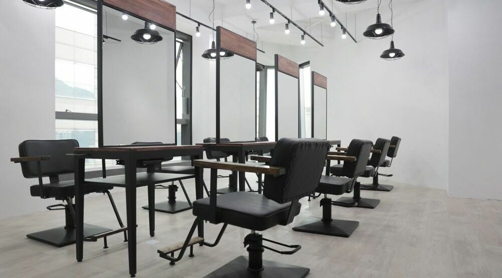Modern salon setup at ASSORT HONG KONG, Hong Kong Island, HK, featuring sleek black chairs and mirrors.