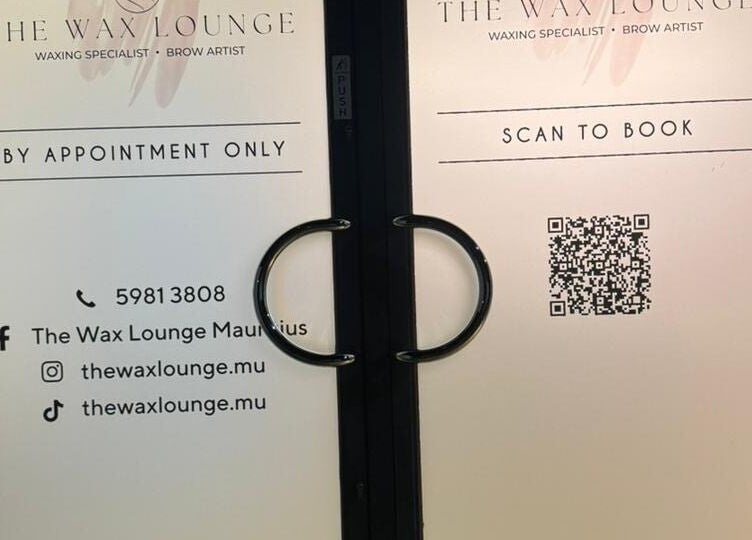 Entrance to The Wax Lounge Mauritius in Port Louis District, MU, showcasing contact details and a booking QR code.