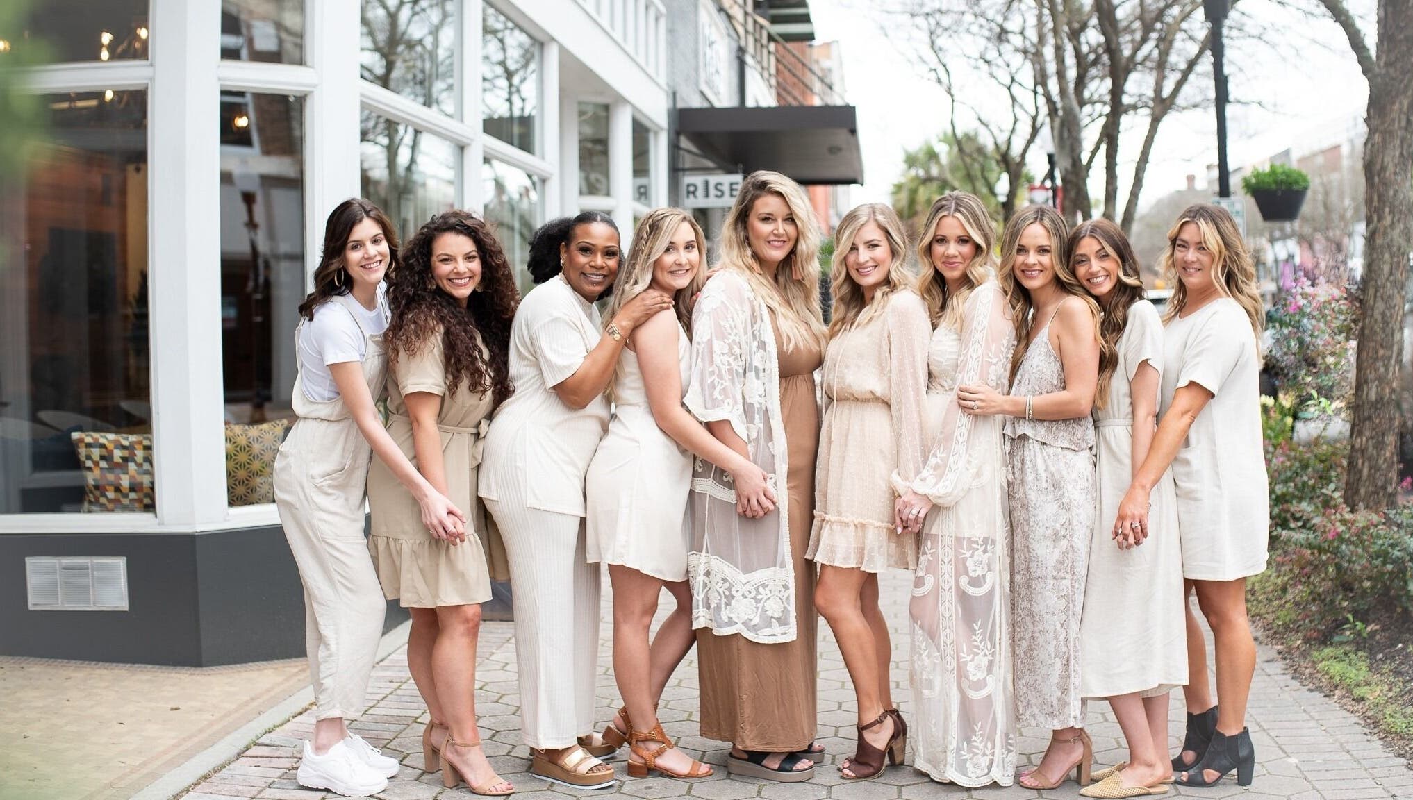 Team of stylists smiling outside Whimsy Salon, Valdosta, Georgia, US, showcasing salon's welcoming vibe.