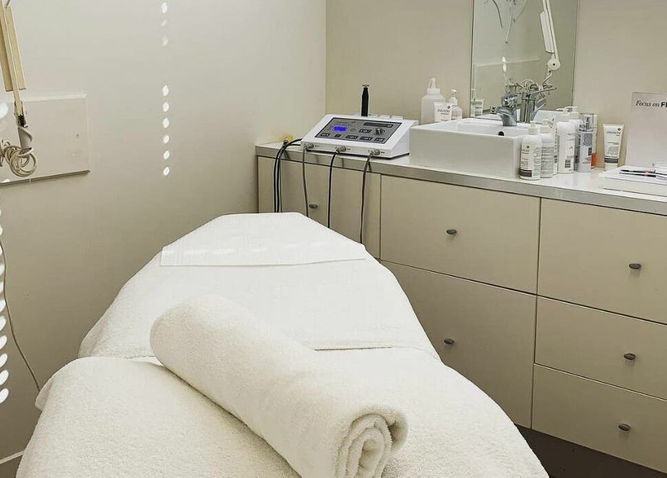Tranquil treatment room at E-Sab Clinic, Benowa, Queensland, AU, with a pristine white bed and modern equipment.