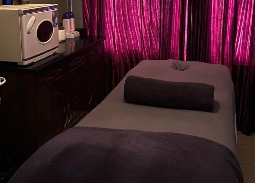 Luxurious massage room at Prestige Luxe Spa, Accra, Greater Accra Region, GH, featuring plush towels and ambient lighting.
