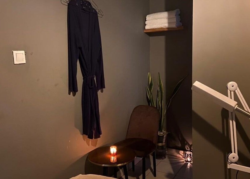 Cozy massage room at Prestige Luxe Spa, Accra with robe, candle, and massage equipment for a relaxing ambiance.