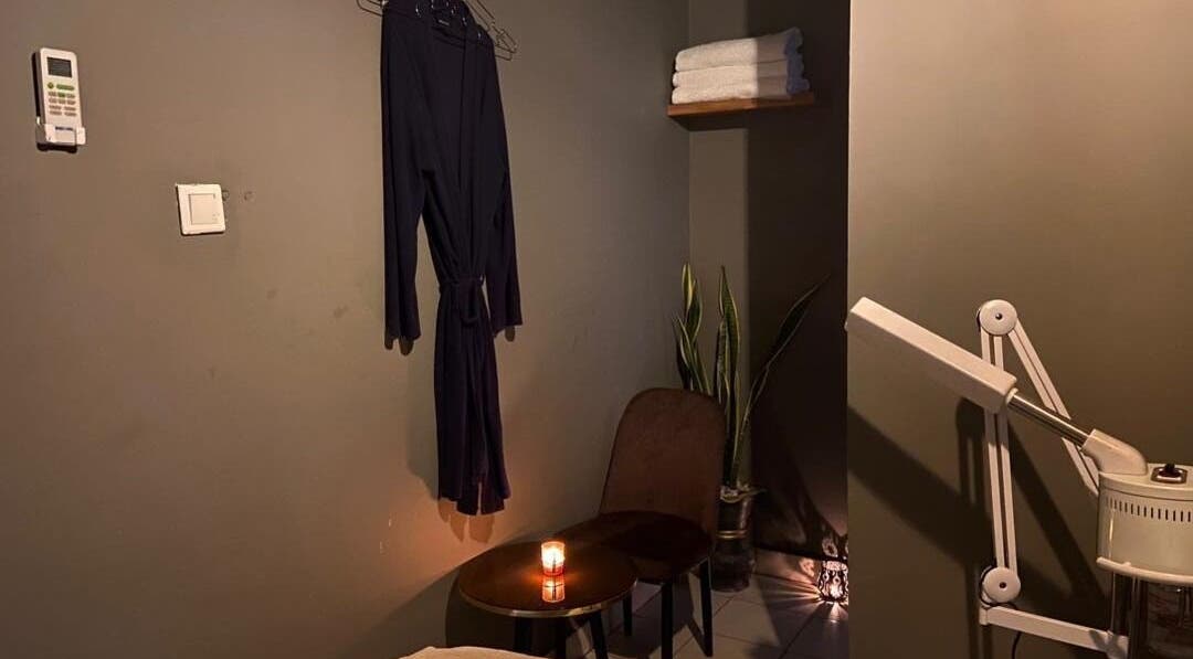 Cozy massage room at Prestige Luxe Spa, Accra with robe, candle, and massage equipment for a relaxing ambiance.