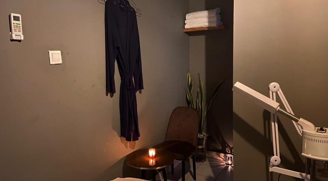 Cozy massage room at Prestige Luxe Spa, Accra with robe, candle, and massage equipment for a relaxing ambiance.