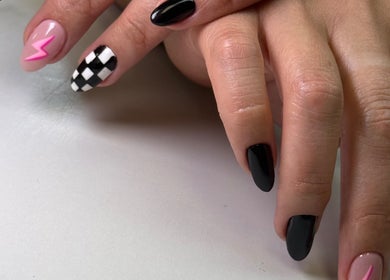 Stylish nail art at Beauty By Lid Nail Studio in Santa Clarita, California, US showcasing black, pink, and checkered designs.