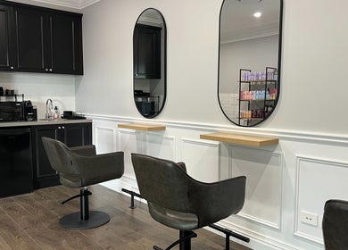 Sleek salon interior at Hair by Laura Marie in Camden, NSW, AU featuring modern chairs and mirrors.