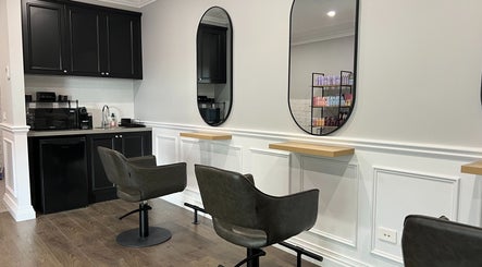 Sleek salon interior at Hair by Laura Marie in Camden, NSW, AU featuring modern chairs and mirrors.