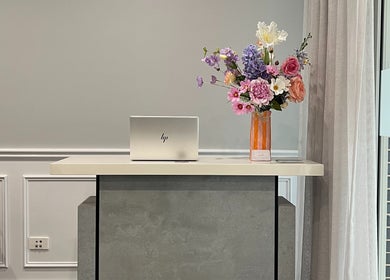 Reception area at Hair by Laura Marie in Camden, New South Wales, AU with laptop and floral arrangement.
