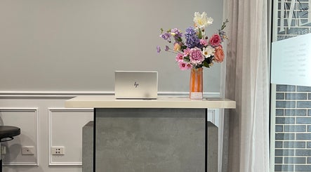 Reception area at Hair by Laura Marie in Camden, New South Wales, AU with laptop and floral arrangement.