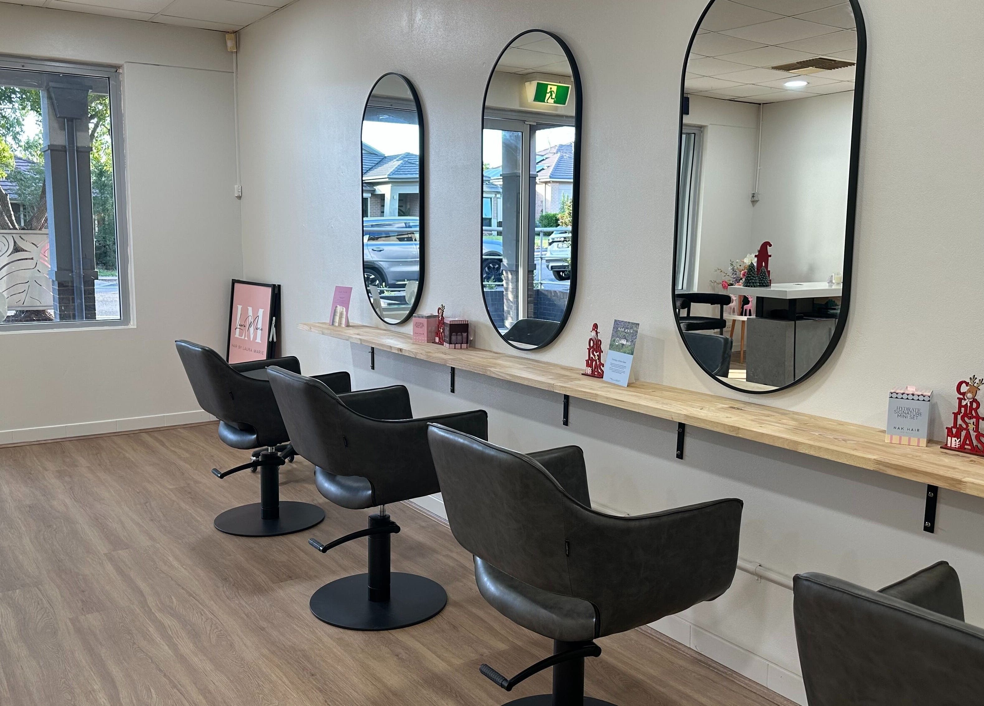 Stylish salon interior at Hair by Laura Marie, Mount Annan, New South Wales, AU with modern chairs and mirrors.